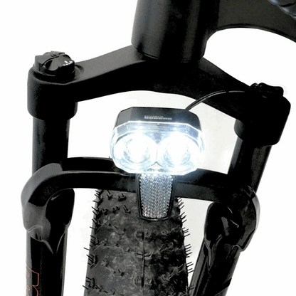 Front view of the FAT-HS eBike’s headlight, mounted on the suspension fork, providing illumination for riding in low light conditions.