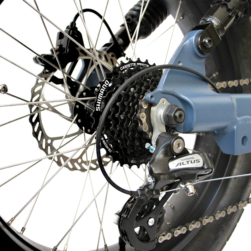 Close-up of an e-bike's rear wheel drivetrain system, featuring Shimano cassette sprockets and a Shimano Altus derailleur, ensuring smooth gear shifting and reliable performance.