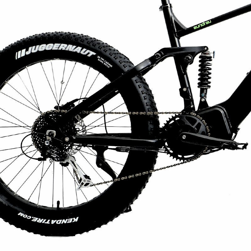 Side view of the FAT-HS eBikeâ€™s rear suspension system, showing the shock absorber, large fat tire with "Juggernaut" branding, and chainring.