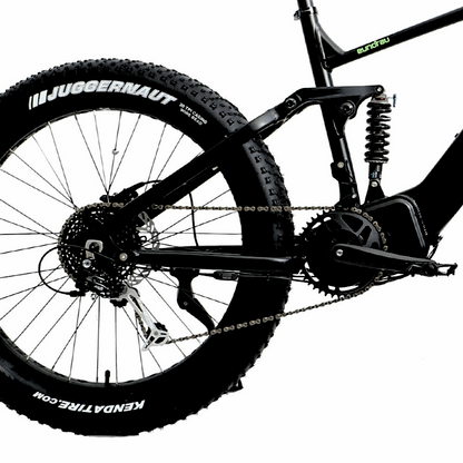 Side view of the FAT-HS eBike’s rear suspension system, showing the shock absorber, large fat tire with "Juggernaut" branding, and chainring.