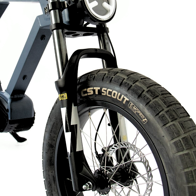 Close-up of an e-bike's front suspension fork and CST Scout tire, providing enhanced stability and traction for various terrains.