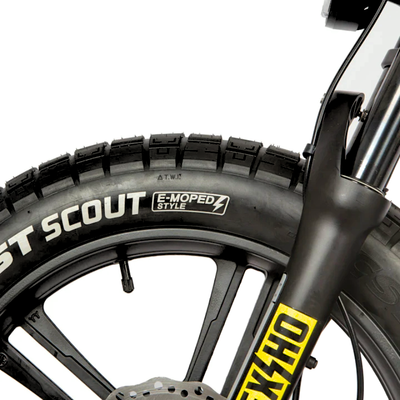 Close-up of an e-bike's front CST Scout tire and suspension fork, designed for stability and traction on various terrains.