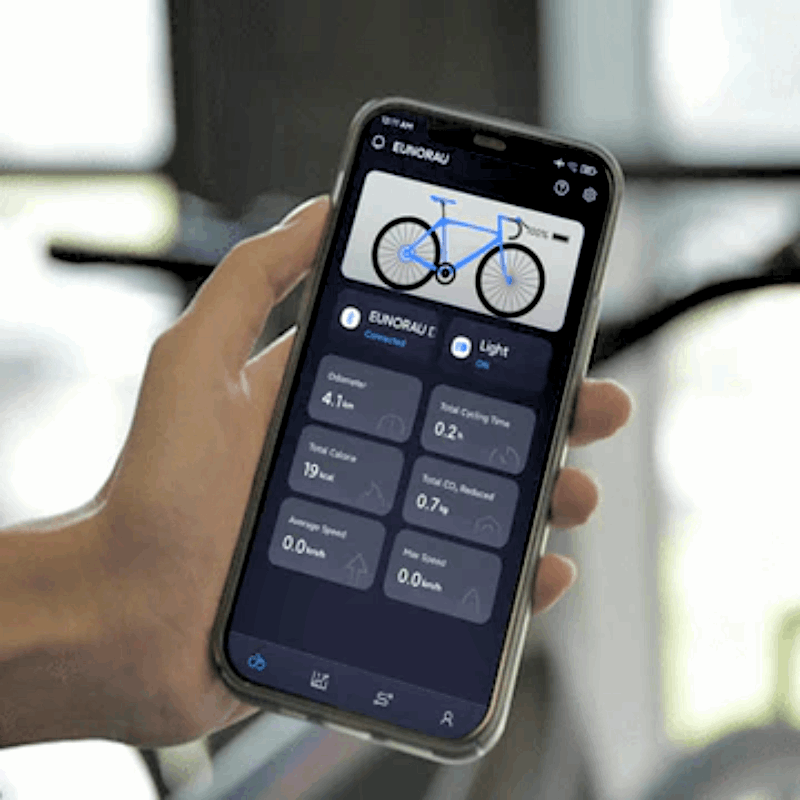 Hand holding a smartphone displaying the EUNORAU app interface, showcasing smart functions such as calorie tracking, trip records, and other ride data synced from an e-bike.