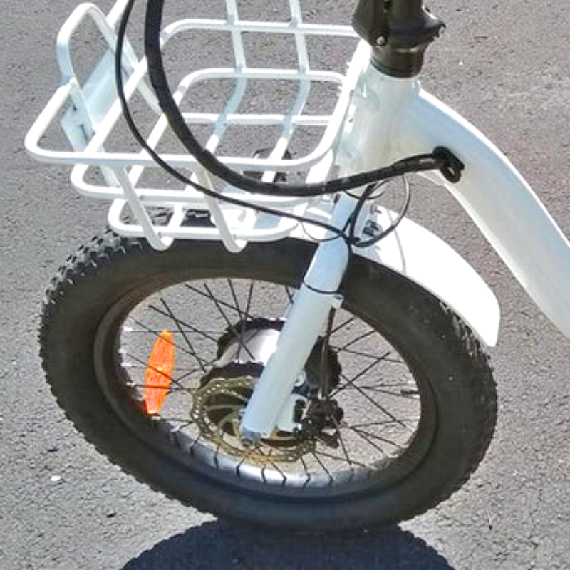 Close-up of the front wheel with the eTRIKE's fat tires and front basket, designed for heavy payloads.