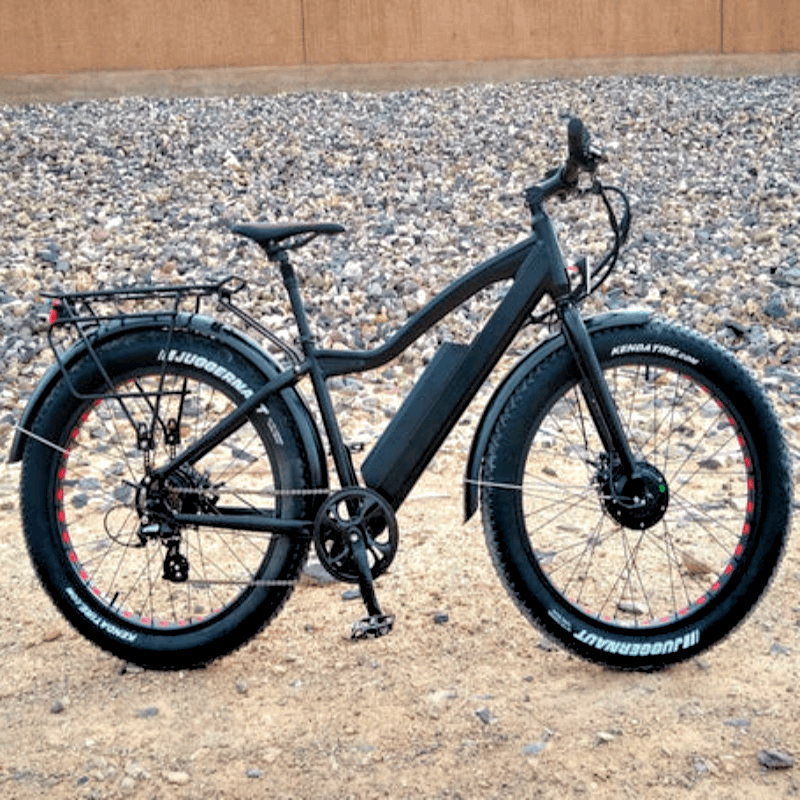 Black electric fat-tire bike in an outdoor setting, built for all-terrain performance and equipped with large Kenda tires.