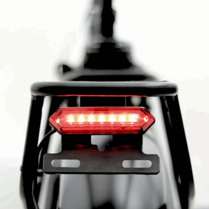 Rear LED tail light of the FAT-MN Folding eBike mounted on the rear cargo rack, ensuring visibility for safety during rides.