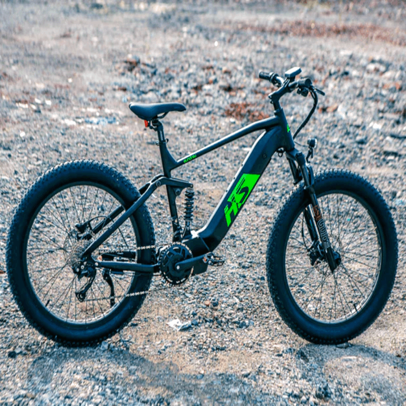 Side view of the FAT-HS eBike on rugged terrain, emphasizing the fat tire setup and sturdy frame, ideal for off-road riding.