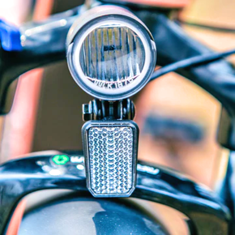 Close-up of the front headlight and reflector on the EUNORAU eBike.